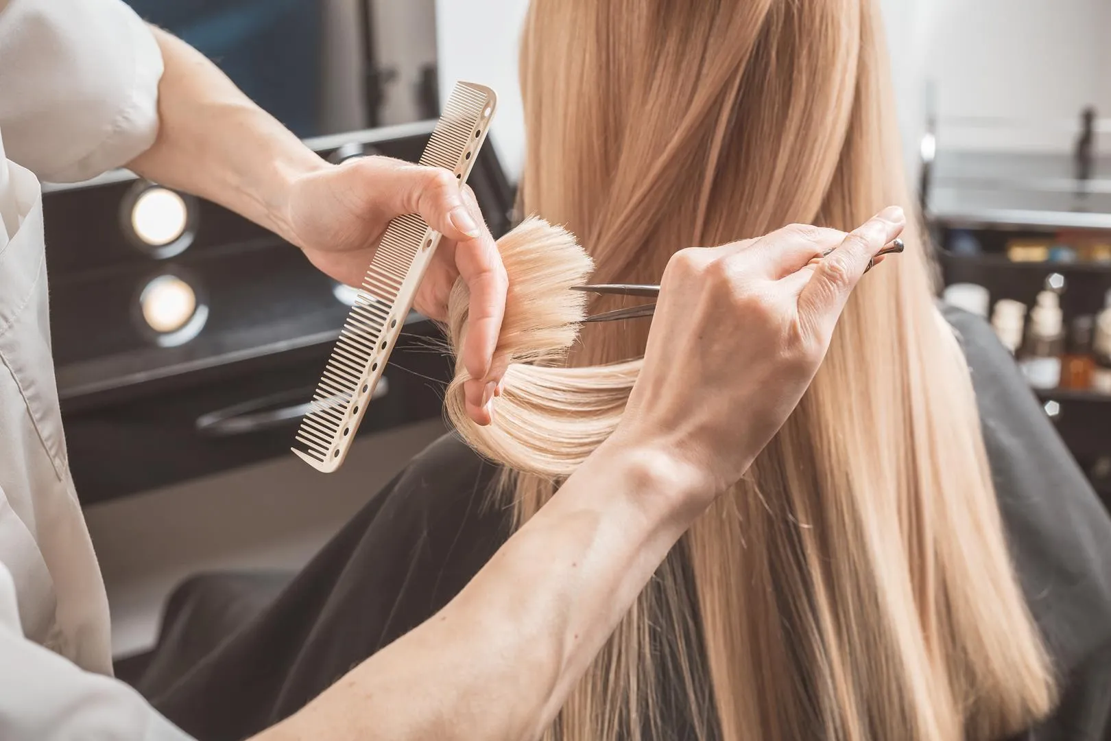 Friseur schneidet im Friseursalon lange Haare